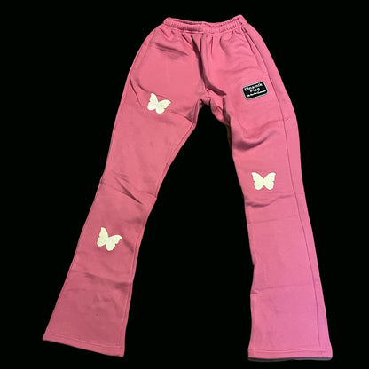 Dinamikplug pink cotton sweatpants with butterfly puff prints and a black logo patch.