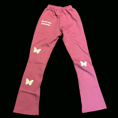 Pink cotton sweatpants with white butterfly patches and puff print slogan Takeover Your Environment.